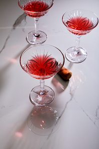 High angle view of glasses of cocktail and cork on white background