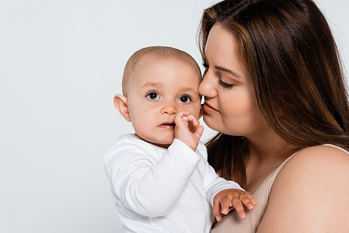 Portrait of mother with overweight looking at baby daughter isolated on grey