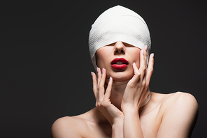 woman in elastic bandage with covered eyes and bare shoulders isolated on grey