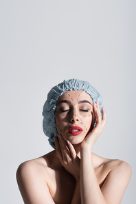 young woman in surgical cap touching face with marked lines isolated on grey