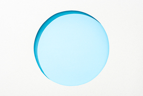 cut out round hole in white paper on light blue colorful background
