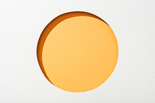 cut out round hole in white paper on orange background