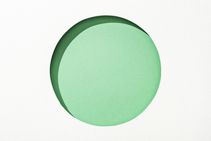 cut out round hole in white paper on green background