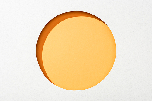cut out round hole in white paper on orange colorful background