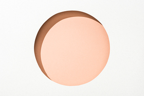 cut out round hole in white paper on beige pastel background