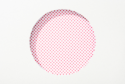 cut out round hole in white paper on pink and white dotted background