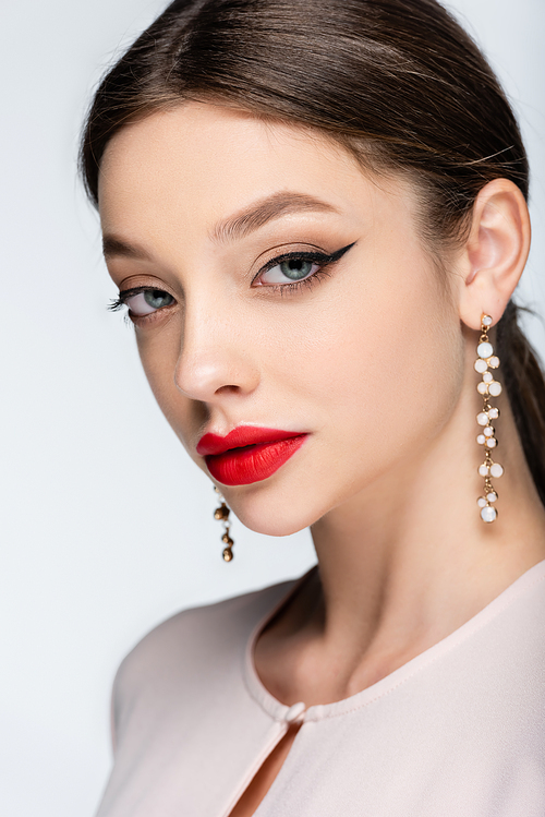young woman in earrings and with red lips  isolated on grey