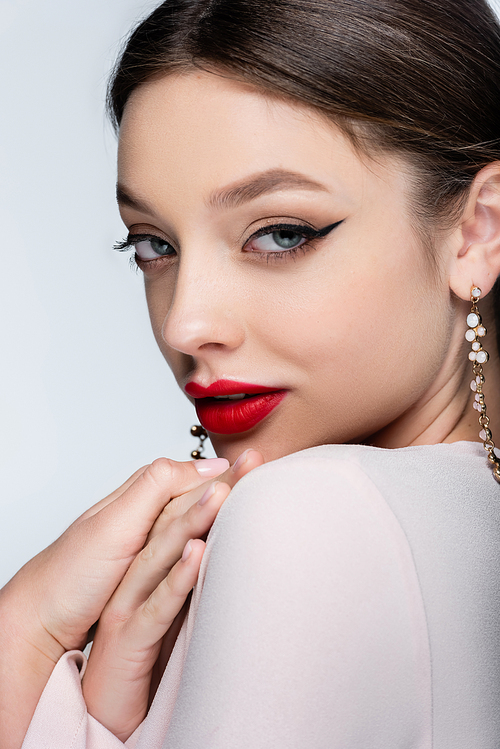 pretty woman in earrings and bright makeup isolated on grey
