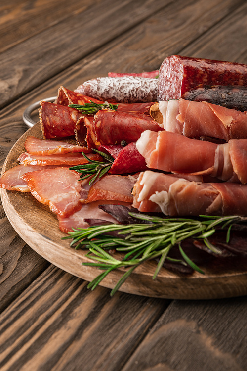 delicious meat platter served with rosemary on wooden board
