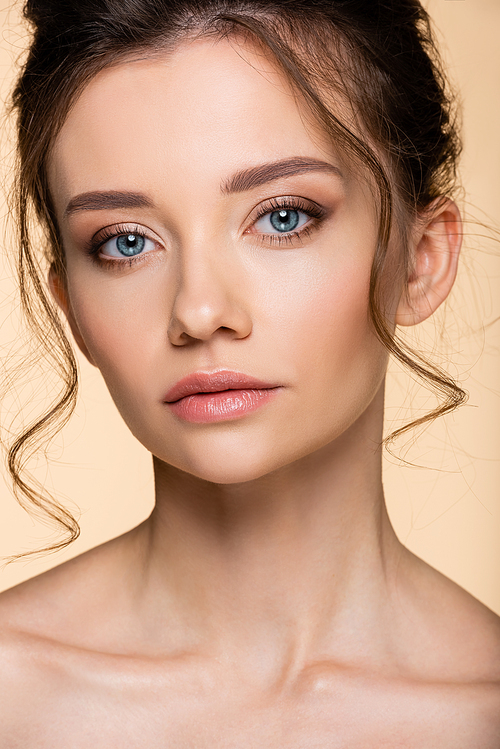 Portrait of young model with makeup  isolated on beige