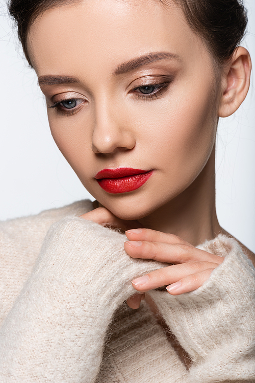 Portrait of pretty model with red lips wearing warm sweater isolated on white