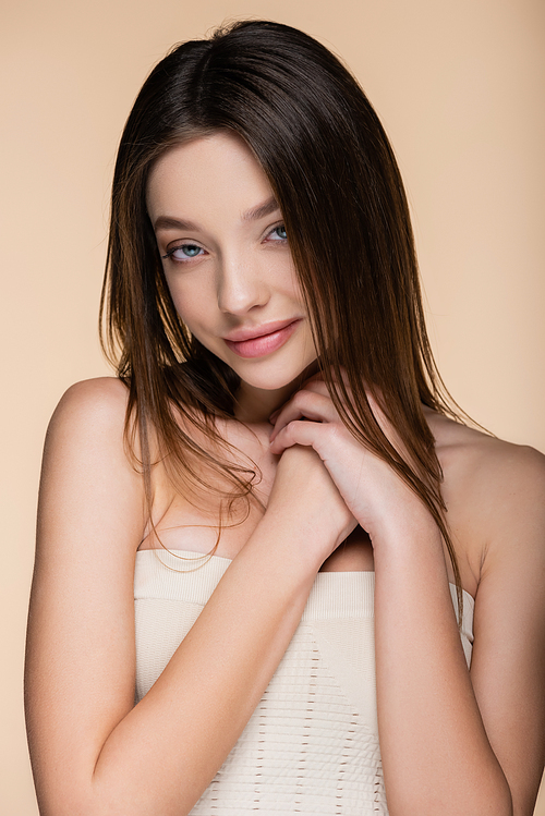 happy model with brunette hair isolated on beige
