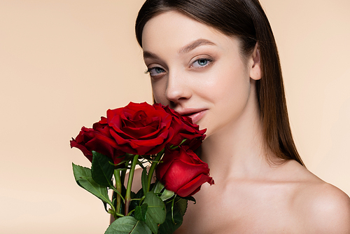 young woman near bouquet of red roses isolated on beige