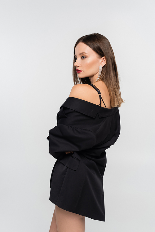 sexy brunette woman in black blazer posing isolated on grey