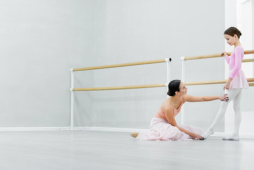 side view of ballet master teaching girl in dance school