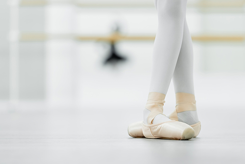 cropped view of girl in pointe shoes in ballet studio