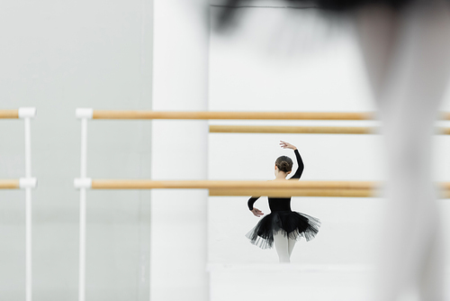 mirror reflection of girl dancing in ballet studio, blurred foreground