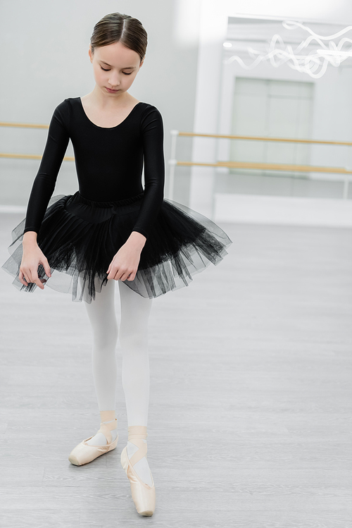 full length view of slim and graceful girl rehearsing in ballet studio