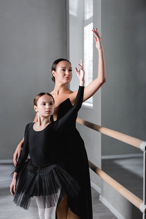 preteen girl dancing with ballet master in studio
