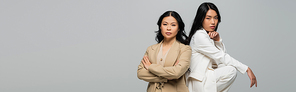 asian young adult woman posing with brunette mother isolated on grey, banner