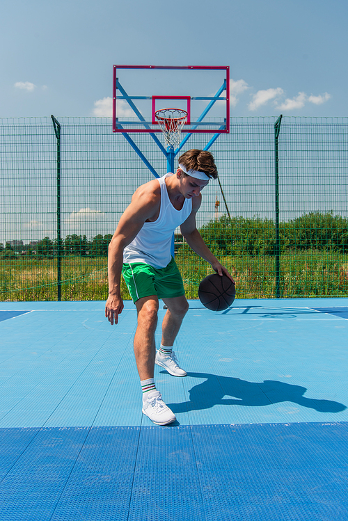 Young sportsman playing streetball on outdoor playground