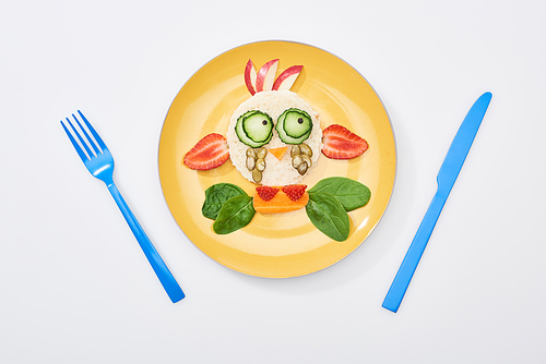 top view of plate with fancy cow made of food for childrens breakfast near cutlery on white background