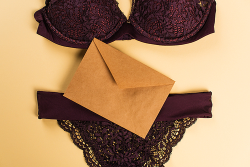 Top view of envelope and lace lingerie on beige background