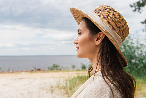 pleased woman in sun hat near sea