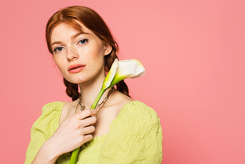 Freckled woman with calla lily  isolated on pink