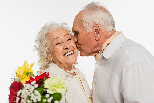 happy elderly man kissing wife with bouquet of flowers isolated on white