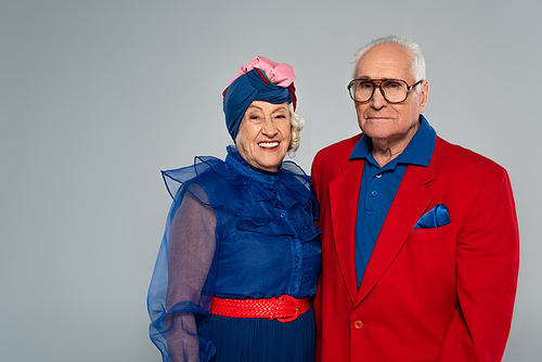 smiling elderly couple in stylish clothes  isolated on grey