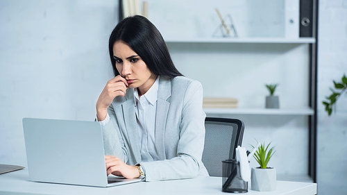worried businesswoman using laptop in office