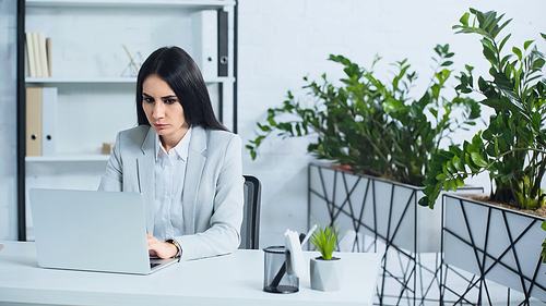 dissatisfied businesswoman using laptop in modern office