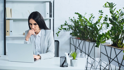 worried businesswoman using laptop in modern office