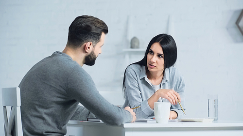woman talking with man while discussing accounting and taxes at home