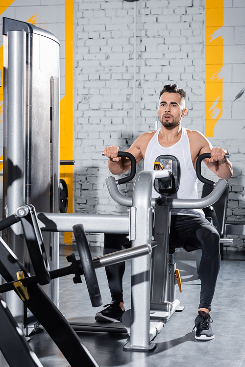 Sportsman training on ab crunch machine in gym