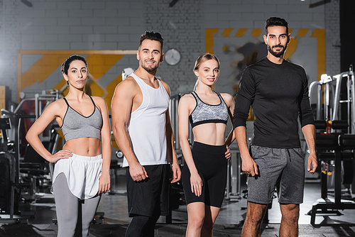 Cheerful interracial people in sportswear  in gym