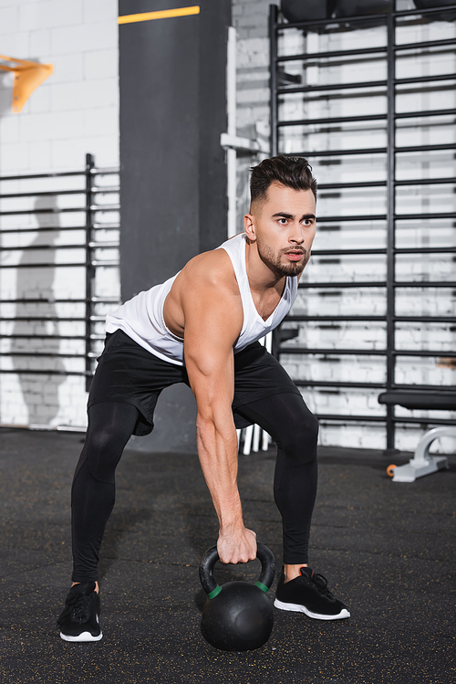 Sportsman holding kettlebell in sports center