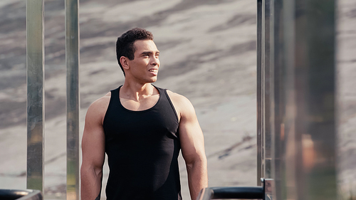 athletic mixed race man looking away at outdoor gym on blurred foreground