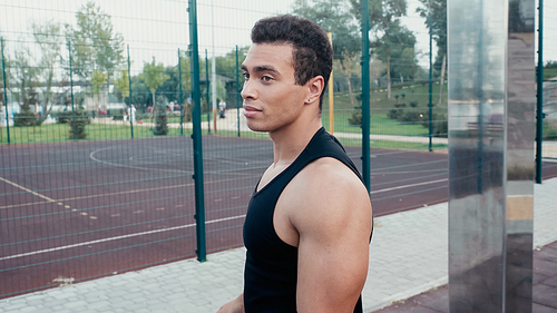 athletic mixed race man standing at outdoors gym