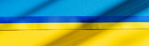 Top view of blue and yellow ribbon on ukrainian flag with shadow, banner