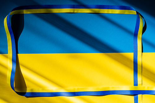 Top view of frame from blue and yellow ribbon on ukrainian flag with shadow