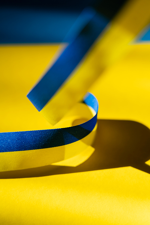 Close up view of blurred blue and yellow ribbon with shadow on ukrainian flag