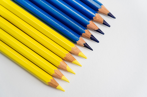 Top view of blue and yellow pencils on white background