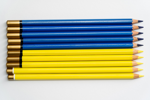 Top view of color blue ad yellow pencils on white background