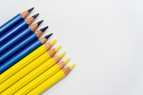 Top view of yellow and blue color pencils on white background with copy space