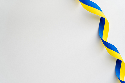 Top view of curly yellow and blue ribbon on white background