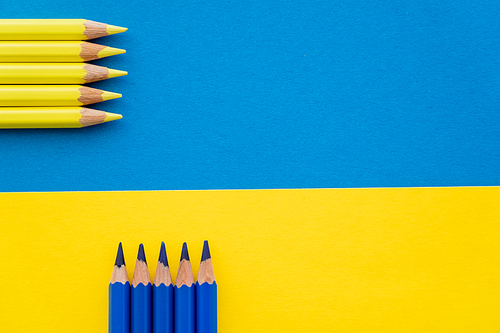 Top view of color pencils on ukrainian flag with copy space