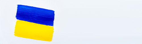 Top view of painted blue and yellow ukrainian flag on white background, banner