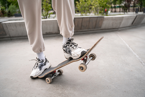 partial view of man in sneakers skating outdoors